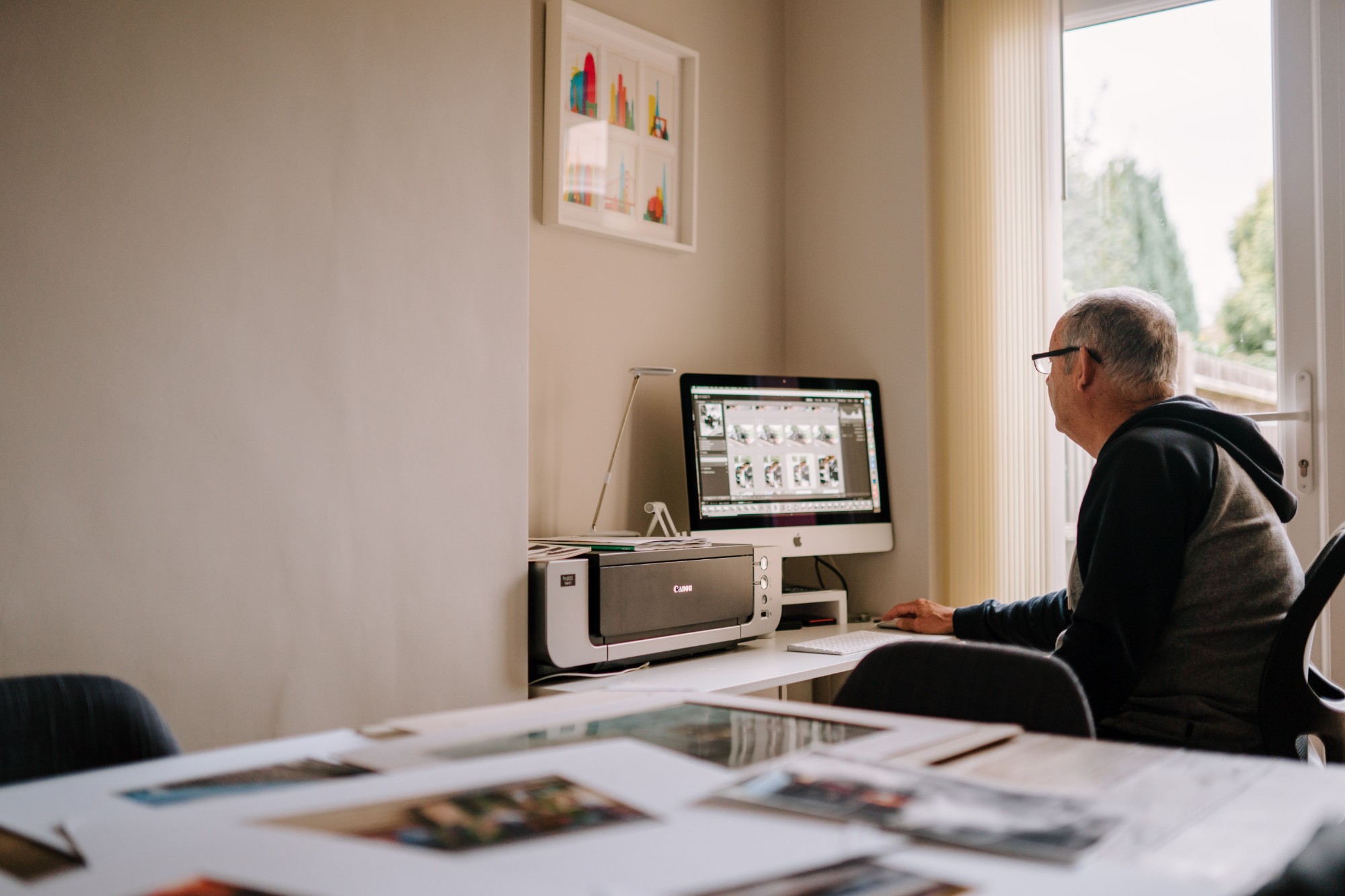 Older man working at a desktop computer in his home office